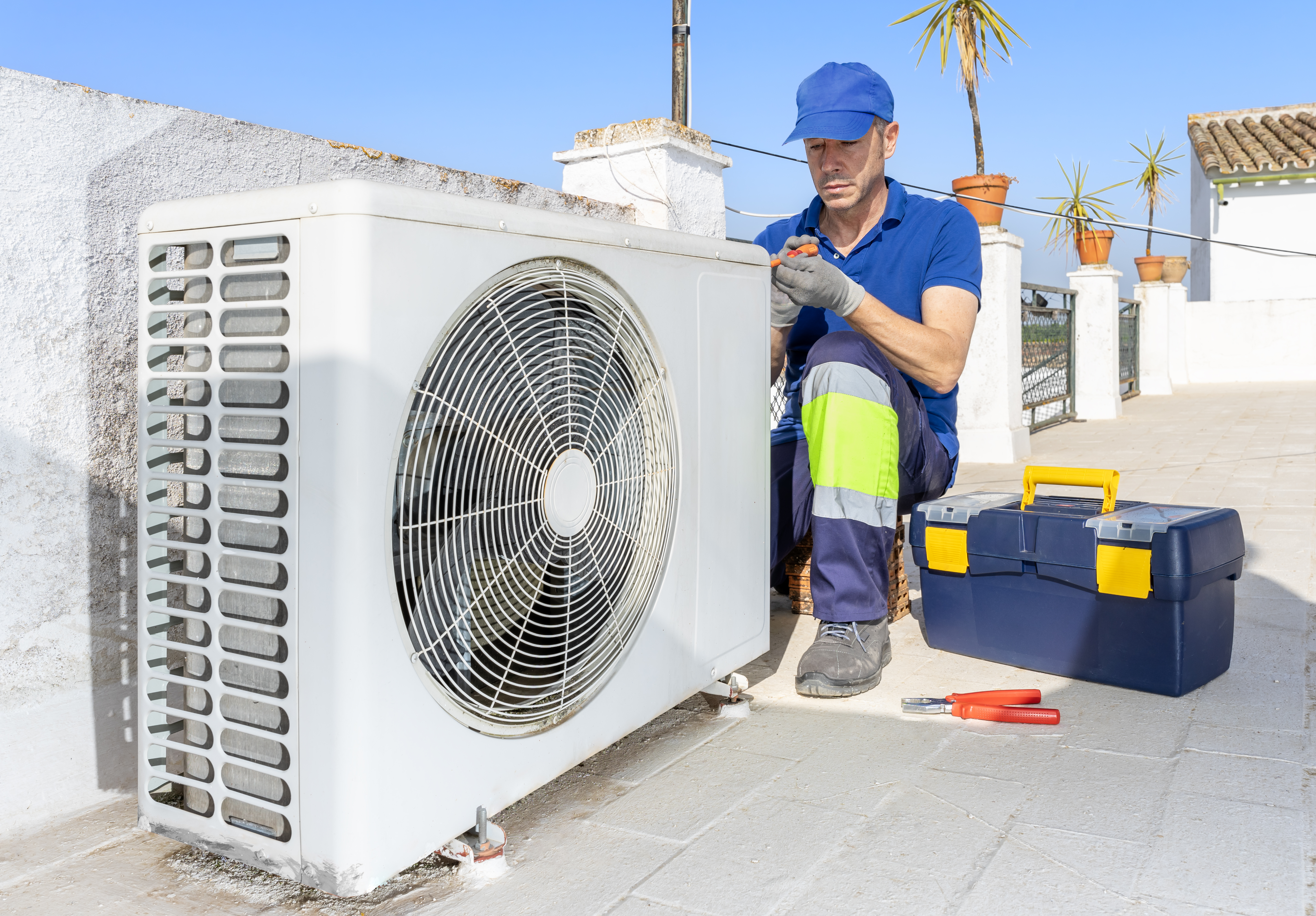 Hvac technician performing air conditioner condenser unit maintenance inspection outdoor on the rooftop. 24 hours emergency repair service for air conditioning and heating systems breakdowns and failures. Home insurance.